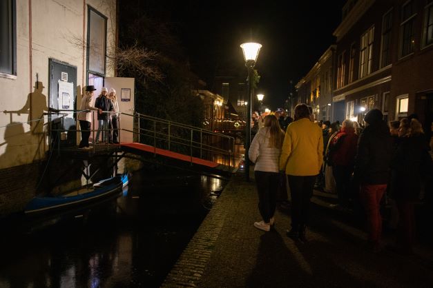 Toeschouwers kijken naar een optreden op 1 van de bruggetjes op de Peperstraat -Foto Astrid den Haan