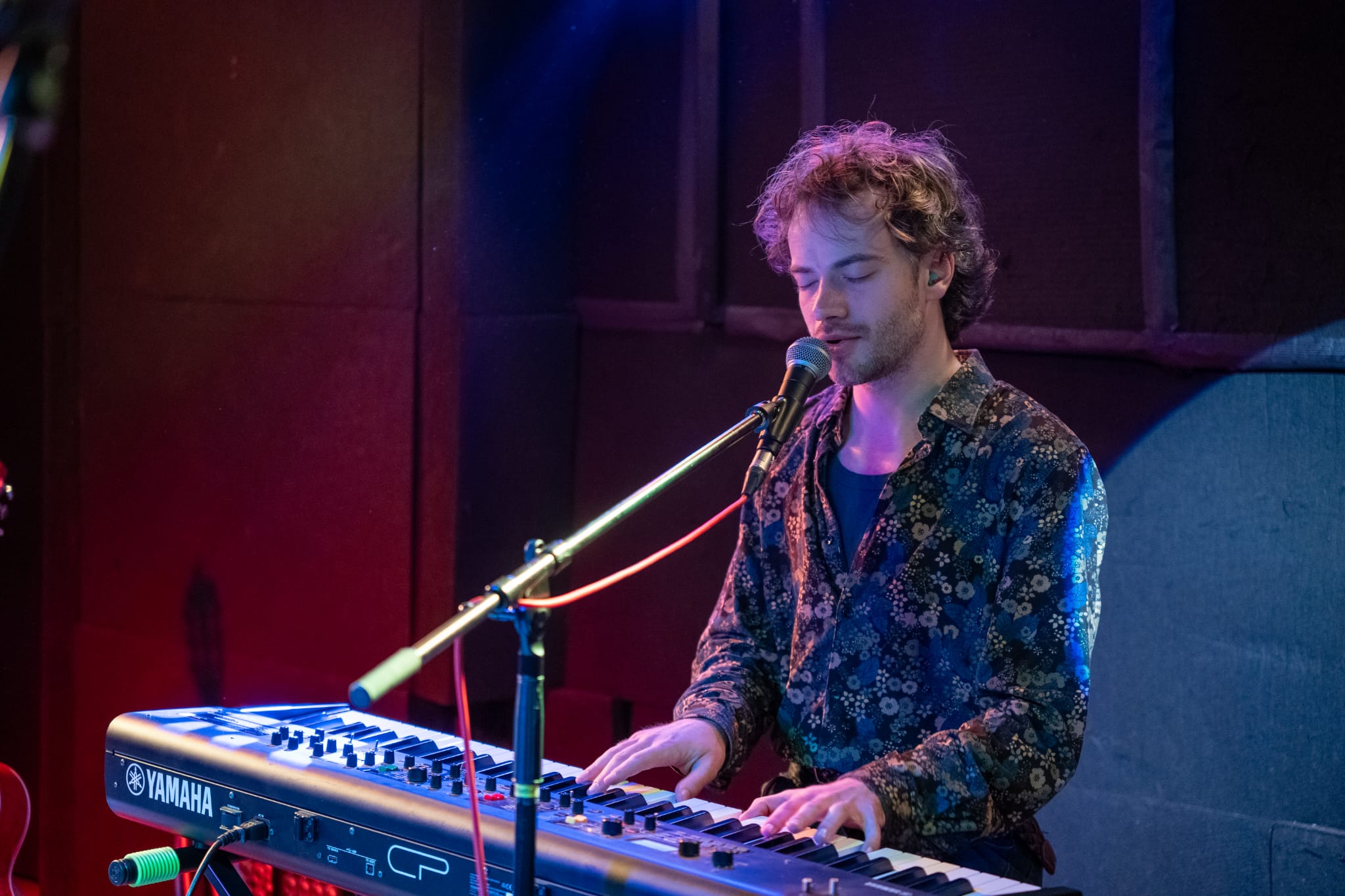 17 noeste mannelijke zangers in groepsfoto met voor hen 2 mannen met acordeon en 1 met gitaar